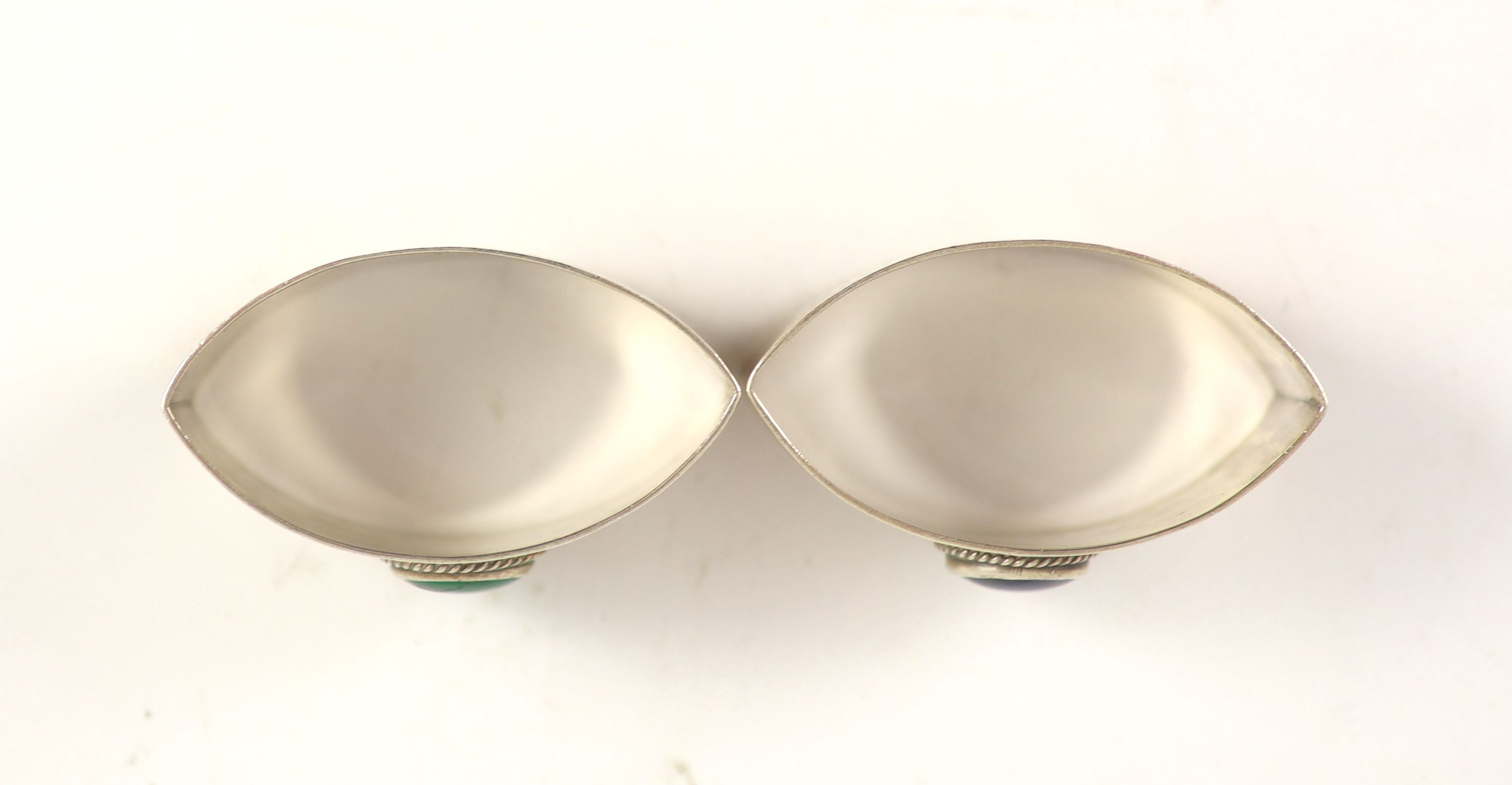 A pair of 1930's Liberty & Co planished silver navette shaped napkin rings, with inset cabochon stone